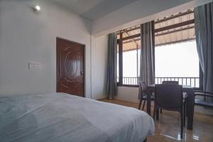 una camera con letto, tavolo e sedie di Spandan Villas a Dhanaulti