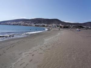 una playa con gente caminando por la arena y el océano en Casa Reina, en Gran Tarajal