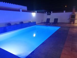 una piscina por la noche con luces azules en Casa Reina, en Gran Tarajal