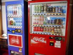 a cocacola soda machine next to a soda vending machine at Kongo Sanmaiin in Koyasan