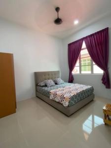 a bedroom with a bed with purple curtains and a window at homestay kubang ikan chendering 5minit ke pantai in Kuala Terengganu
