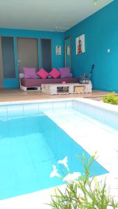 a large swimming pool with a couch in a room at Meno Suites in Gili Meno