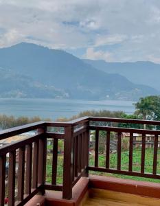 a wooden balcony with a view of the water at Hotel Chino Pokhara in Pokhara