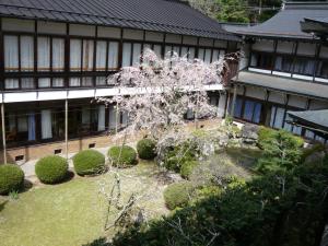 un árbol en un jardín frente a un edificio en Kongo Sanmaiin, en Koyasan