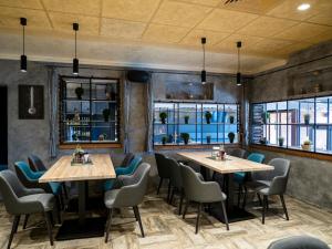 a restaurant with two tables and chairs and windows at Hotel Elit in Pernik