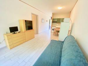マリーナ・ディ・ビッボーナにあるApartments Via Dei Plataniのリビングルーム(ベッド1台付)、キッチンが備わります。