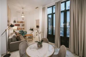 sala de estar con mesa y sillas en Precioso apartamento con patio en La Alameda, en Sevilla