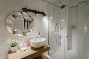 y baño con lavabo y ducha con espejo. en Precioso apartamento con patio en La Alameda, en Sevilla