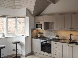 a kitchen with white cabinets and a stove top oven at The Turret in Easingwold