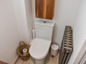 uma casa de banho com WC e um armário por cima em The Turret em Easingwold