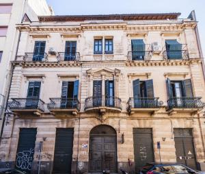 stary budynek z balkonami przy ulicy miejskiej w obiekcie Grimaldi 8 Apartment by Wonderful Italy w Katanii