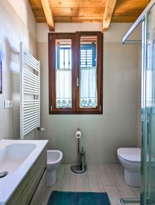 a bathroom with a sink and a toilet and a window at Agriturismo Ardizio 43 in Pesaro