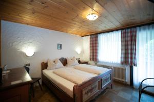 a bedroom with a bed and a wooden ceiling at Gästehaus am Eichbach in Schramberg