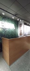 a lobby with a counter with plants on the wall at Apartment House - Delta in Sofia