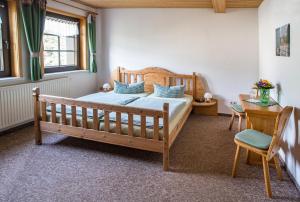 1 dormitorio con cama de madera y mesa en Am Roten Hammer I Gasthof und Pension, en Kurort Oberwiesenthal