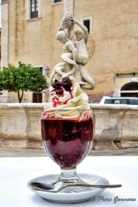 a drink in a glass with whipped cream and berries at B&B del centro storico *** in Rosolini