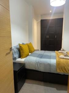 Un dormitorio con una cama con almohadas amarillas. en UIM Mediterraneo PB Libertad Wifi, en Puerto Sagunto