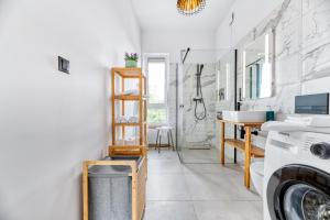 a bathroom with a sink and a washing machine at MONTEZERA Butikowe Ekspedycje Sauna i Widok in Piechowice +59 photos