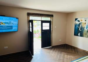 una habitación vacía con puerta y TV en la pared en The Forest Resort - Lweza, en Makindye