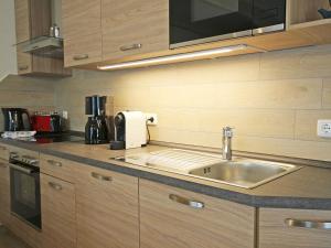 a kitchen counter with a sink and a microwave at Strandhus Baabe Haus 3 in Baabe