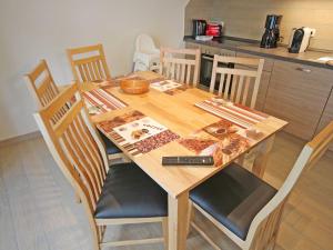 a wooden table with four chairs and a kitchen at Strandhus Baabe Haus 3 in Baabe