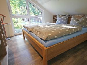 a bed in a bedroom with a large window at Strandhus Baabe Haus 3 in Baabe