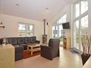 ein Wohnzimmer mit einem Sofa und einem TV in der Unterkunft Strandhus Sellin - Apt. 02 in Ostseebad Sellin