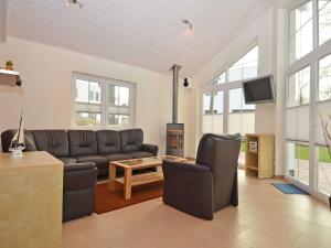 ein Wohnzimmer mit einem Ledersofa und einem TV in der Unterkunft Strandhus Sellin - Apt. 02 in Ostseebad Sellin
