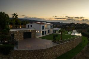 una casa con una pared de piedra y una valla en Villa Sabrina Riviera dei Fiori a Picco sul Mare con Piscina Privata ,WELLNESS & SPA en Imperia