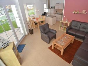ein Wohnzimmer mit einer Couch und Stühlen und einem Tisch in der Unterkunft Strandhus Sellin - Apt. 02 in Ostseebad Sellin + 23 Fotos