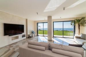 sala de estar con sofá y TV de pantalla plana en Villa Sabrina Riviera dei Fiori a Picco sul Mare con Piscina Privata ,WELLNESS & SPA en Imperia
