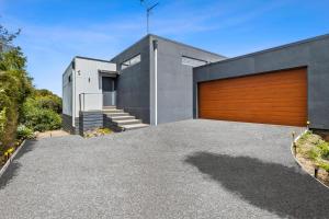 a house with a wooden garage door at Aireys Sunset Beach House in Aireys Inlet