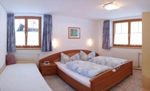 1 dormitorio con 1 cama y 2 ventanas en Ferienwohnung Erhard, en Silbertal