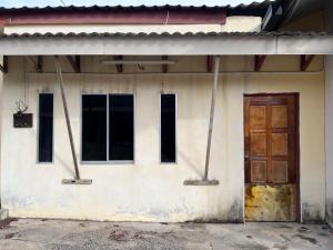um edifício com uma porta de madeira e janelas em SMZ Café & Homestay - SELF CHECK IN em Kodiang