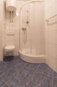 La salle de bains est pourvue d'une douche et de toilettes. dans l'établissement Apartments Sunset -near Queen Beach, à Privlaka