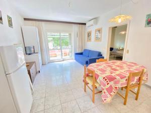 a kitchen and dining room with a table and a blue chair at Apartments Via Dei Platani in Marina di Bibbona