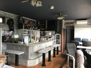 eine Bar mit Tischen und Stühlen in einem Restaurant in der Unterkunft cottage SOUL MATE in Ishigaki-jima