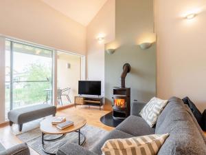 a living room with a couch and a fireplace at Plovers Nest At Lower Mill in Somerford Keynes