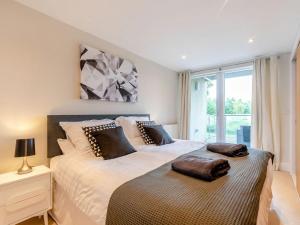 - une chambre avec un grand lit et une fenêtre dans l'établissement Plovers Nest At Lower Mill, à Somerford Keynes