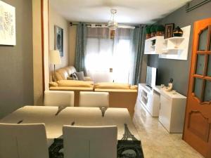 a living room with a table and chairs in a room at Precioso apartamento de lujo in Torredembarra