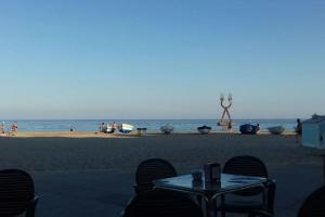 una mesa y sillas en una playa con el océano en Precioso apartamento de lujo en Torredembarra