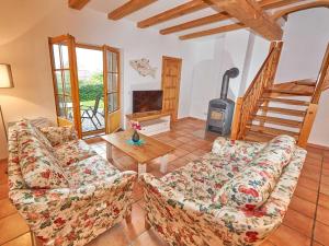 een woonkamer met een bank en een houtkachel bij Strandschlösschen Sellin - Haushälfte 1 in Ostseebad Sellin