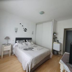 um quarto branco com uma cama e uma televisão em Verolithos em Narrosse