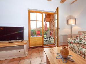 a living room with a tv and a couch and a table at Strandschlösschen Sellin - Haushälfte 2 in Ostseebad Sellin