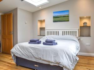 a bedroom with a bed with two towels on it at Durcombe Water Annexe in Barbrook
