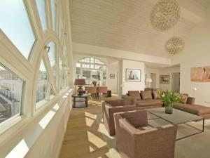 ein Wohnzimmer mit einem Sofa und einem Tisch in der Unterkunft Strandschloss Binz - Penthouse "Royal Beach" mit Sauna, Kamin, Terrasse, Meerblick in Binz