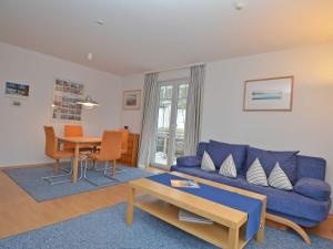 ein Wohnzimmer mit einer blauen Couch und einem Tisch in der Unterkunft Strandwohnungen Sellin - WG04 mit 2 Balkonen in Ostseebad Sellin