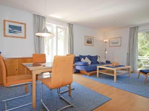 uma sala de estar com uma mesa e um sofá em Strandwohnungen Sellin - WG04 mit 2 Balkonen em Ostseebad Sellin