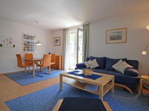 ein Wohnzimmer mit einer blauen Couch und einem Tisch in der Unterkunft Strandwohnungen Sellin - WG04 mit 2 Balkonen in Ostseebad Sellin + 9 Fotos
