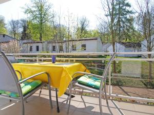 オストゼーバート・ゼリンにあるStrandwohnungen Sellin - WG04 mit 2 Balkonenの黄色のテーブルと椅子が備わるバルコニー